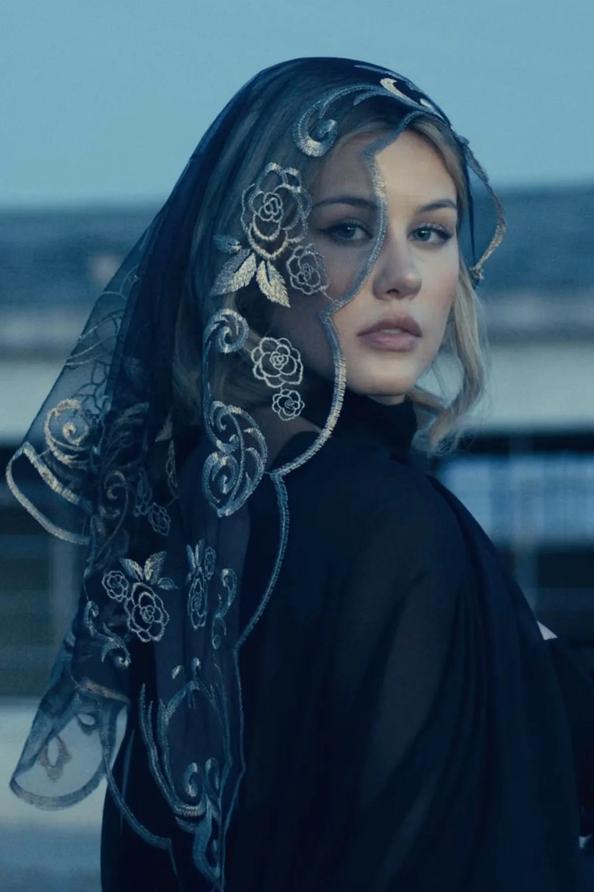 Woman in a black lace dress and veil, a haunted widow among scary Halloween costumes
