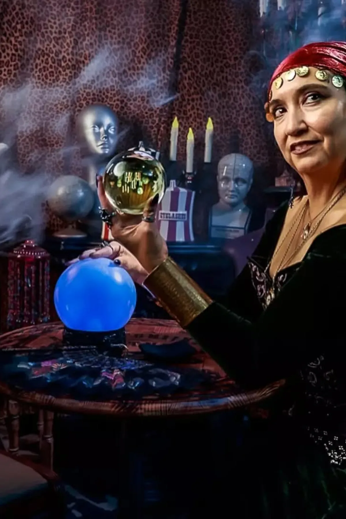 Woman in a paisley shawl and black maxi skirt holding a crystal ball, a haunted fortune teller solo Halloween costume