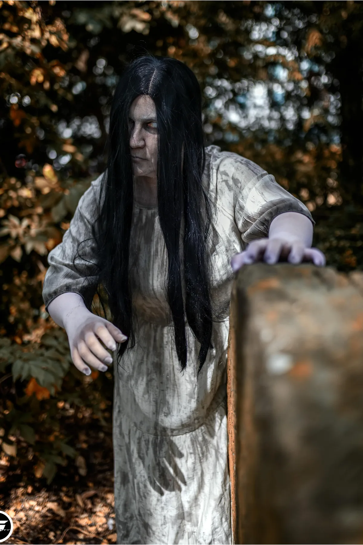 Woman in a white slip dress with long black hair covering her face, a cursed tape girl solo Halloween costume