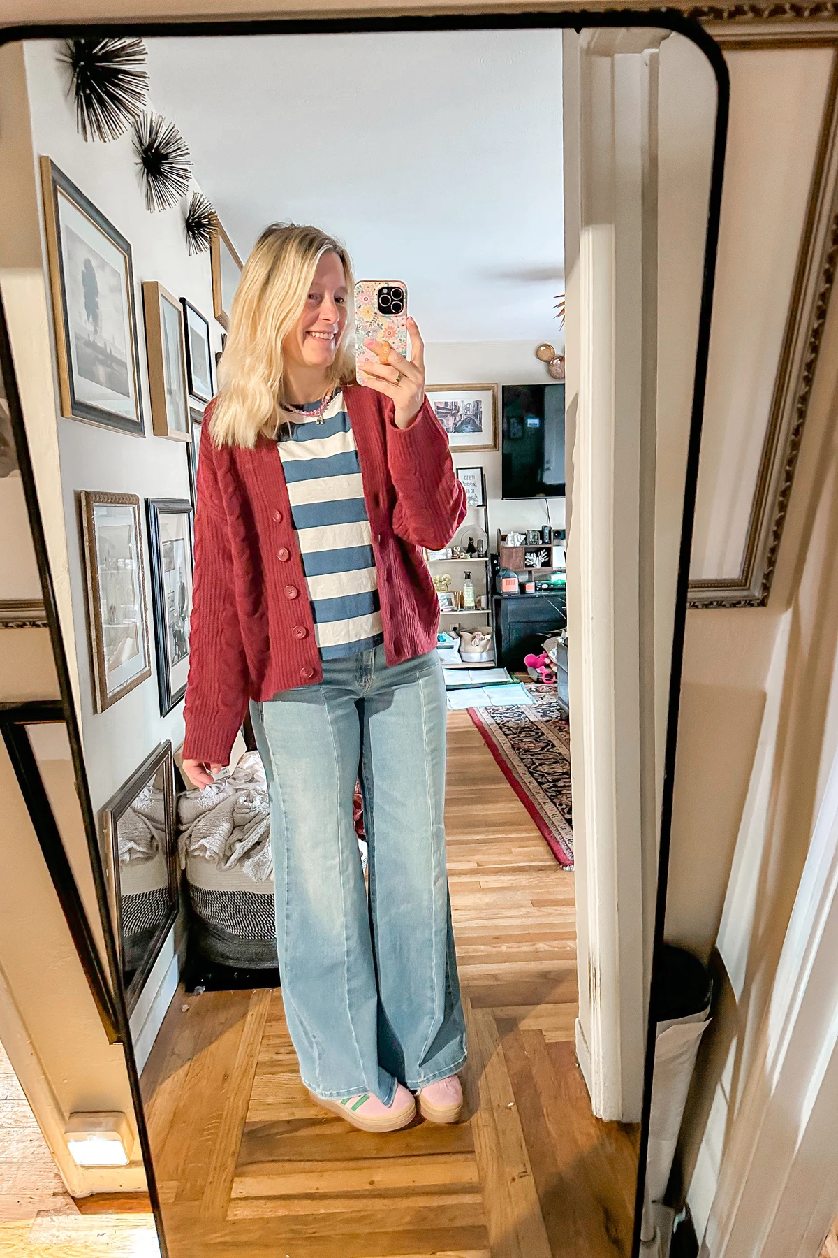 Woman in striped tee, red cardigan and navy wide-leg pants on a ferry deck at Christmas