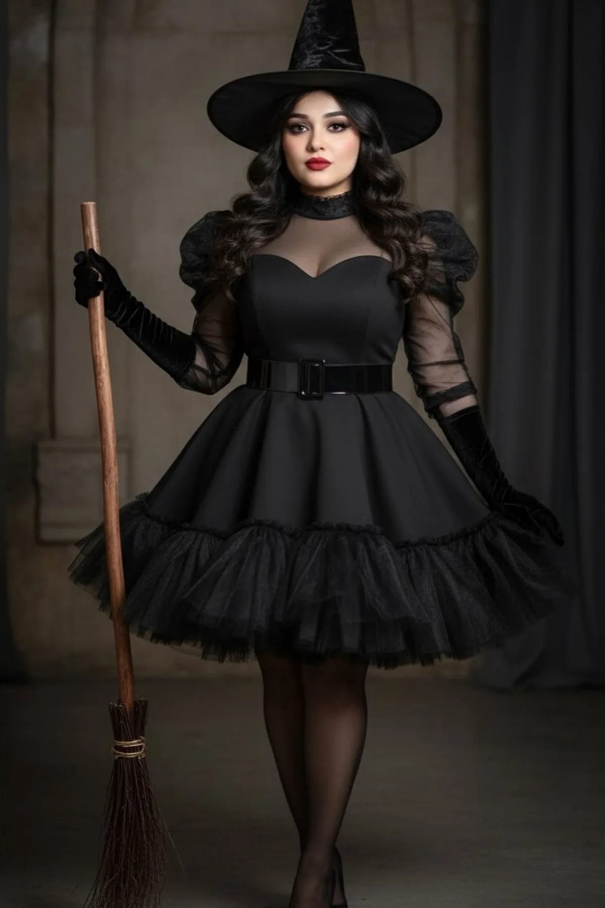 Woman over 50 in a black dress and pointed witch hat holding a broom, a classic last minute witch Halloween costume