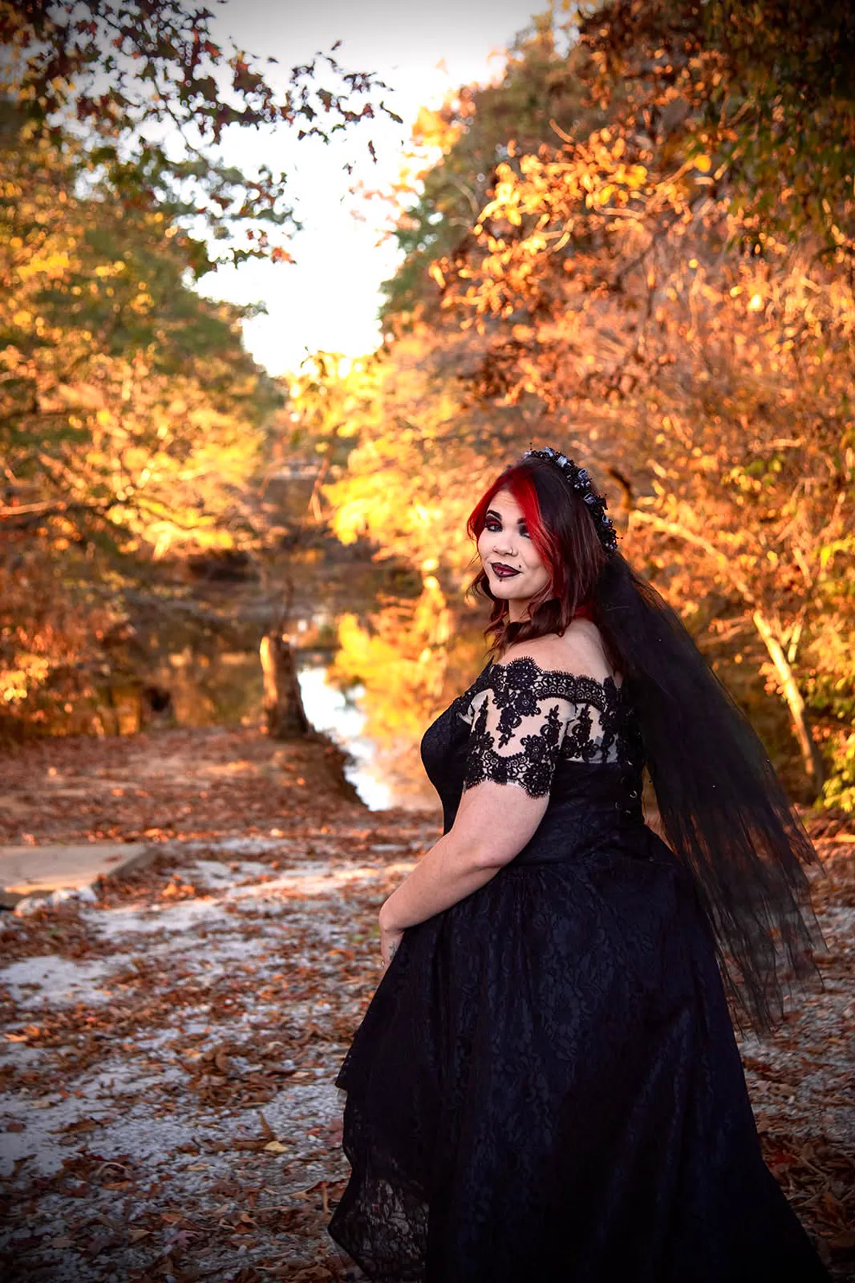 Woman in a black lace dress and veil with dried roses, a gothic plus size witch Halloween costume