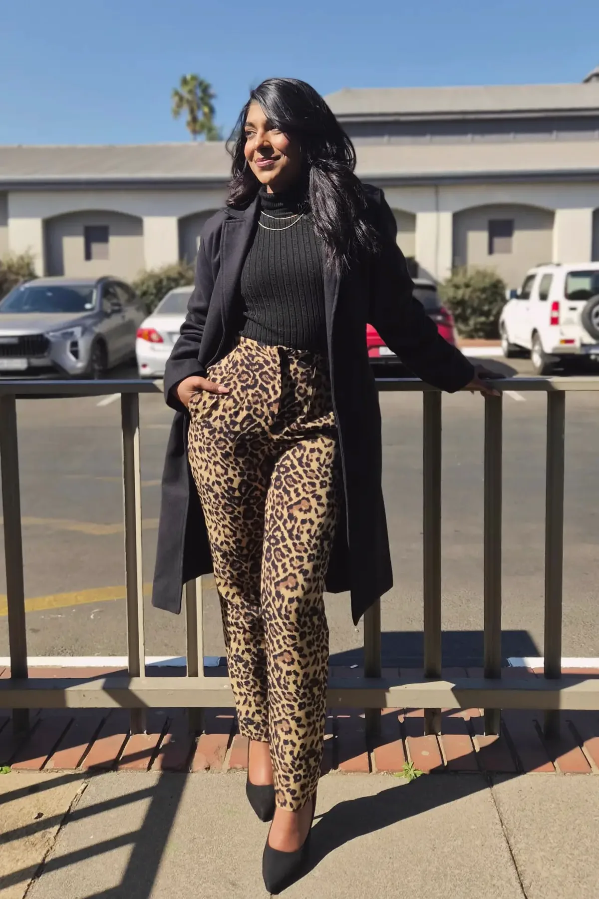 Woman in a black turtleneck and leopard trousers with a mini hat, a plus size cat witch costume